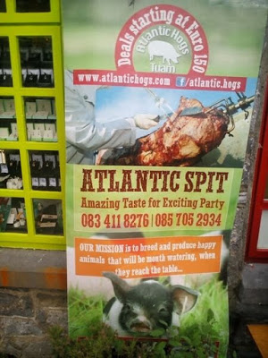 Top image shows a skewered pig's corpse charred and sliced, while bottom image shows a happy piglet in clover. Reads, "Atlantic Spit: Amazing Taste for Exciting Part. Our mission is to breed and produce happy animals that will be mouth watering, when they reach they table..."
